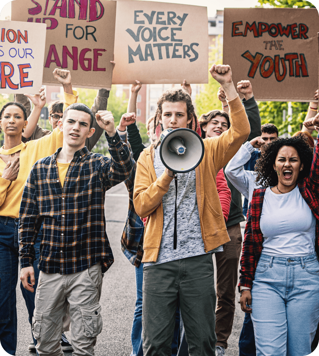 A group of people marching down the street holding signs.