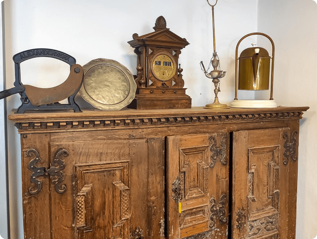 Frame 1618874236 (1) A wooden cabinet with some old clocks on it